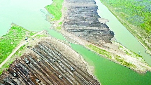 6月13日，沅江市漉湖蘆葦場下塞湖矮圍整治現(xiàn)場,，眾多施工機(jī)械分南堤,、北堤等4個(gè)戰(zhàn)場同步推進(jìn)，拆除矮圍泥堤,。(資料照片)