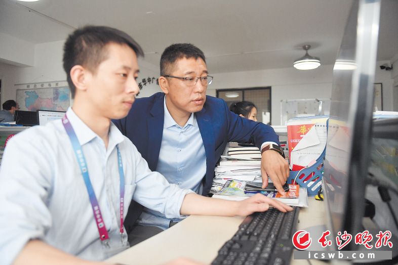 徐文斌（右）在指導(dǎo)同事對(duì)廣告的細(xì)節(jié)進(jìn)行優(yōu)化,，爭(zhēng)取將更多信息傳遞給客戶,。 長(zhǎng)沙晚報(bào)全媒體記者 余劭劼 攝