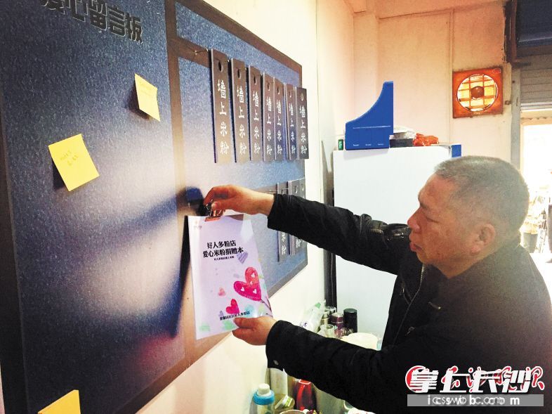 劉國興將每位愛心人士購買“墻上米粉”的賬目詳細(xì)登記，困難群眾只要隨手取一塊“墻上米粉”籌碼,，就能免費吃粉,。長沙晚報記者 李卓 攝