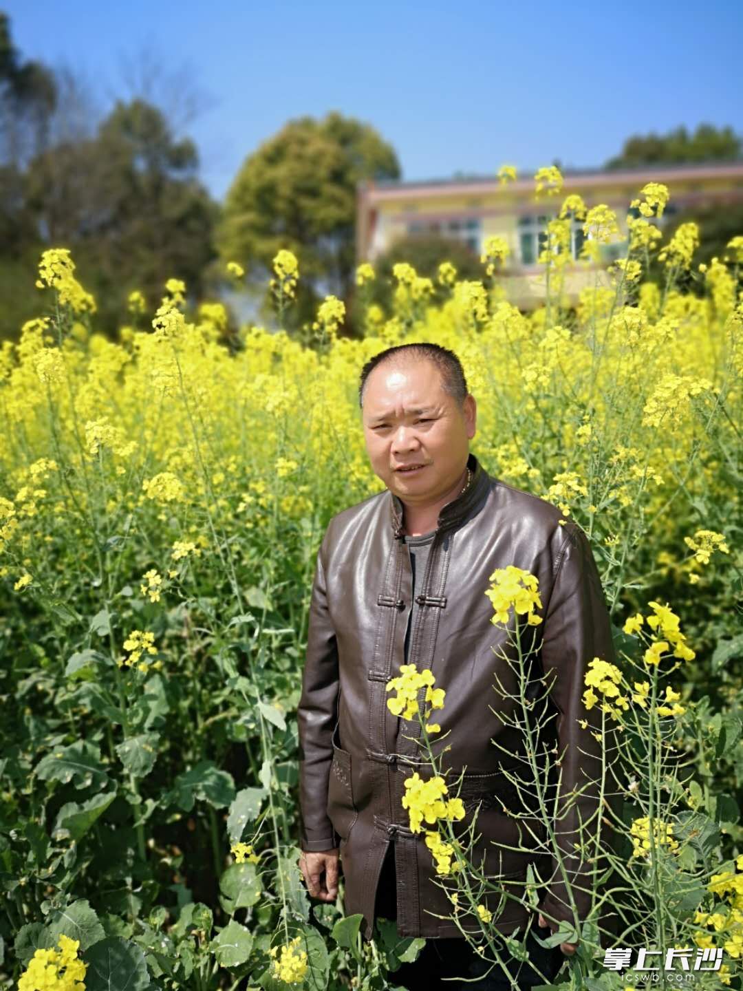 身高1.76米的余羅建站在自己種植的油菜花地里，變得“嬌小”起來(lái),。全媒體記者 朱華 攝