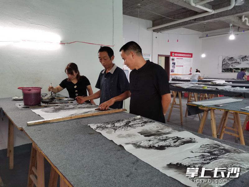 “農(nóng)民畫師”詹秋明（中）與韻墨緣畫室負責人邱貴榮（右）交流。長沙晚報全媒體記者 黃能 攝