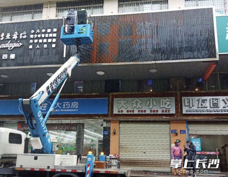 施工人員正在對廣告銹跡進行清除。