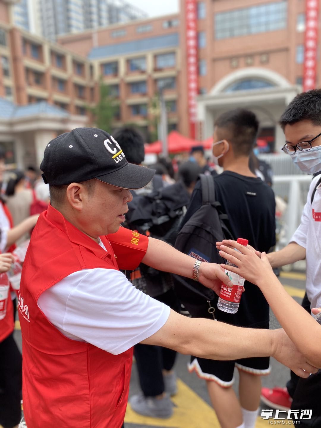 在明德天心中學外，天心區(qū)文源街道金匯社區(qū)30余名“雷鋒志愿者”組成“文源護考志愿服務隊”為考生及家長提供貼心志愿服務,。長沙晚報全媒體記者 匡春林 實習生 夏瑞婷 攝