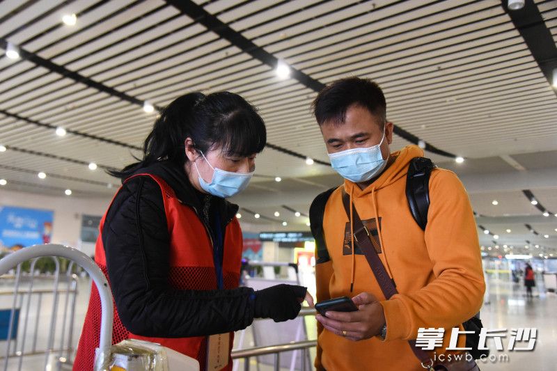 春運首日,，長沙火車南站的志愿者引導乘客出示健康碼并進行查驗。均為長沙晚報全媒體記者 劉琦 攝