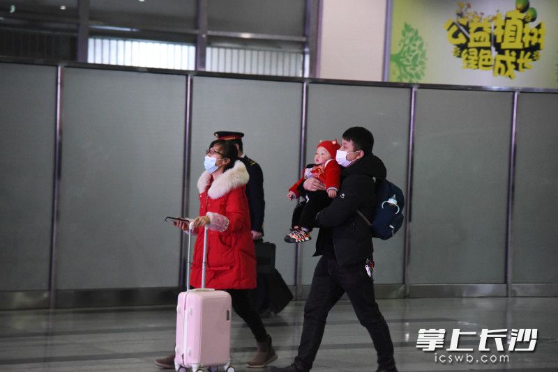 一家三口走出長沙火車南站，步履匆匆,。