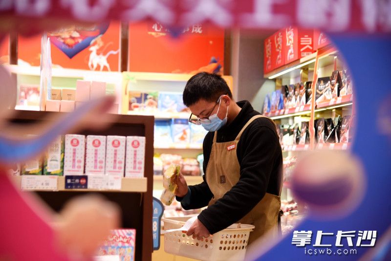 接到外賣訂單,，良品鋪子長沙五一廣場店店長劉興瑞為顧客取貨,。均為長沙晚報全媒體記者 劉琦 攝