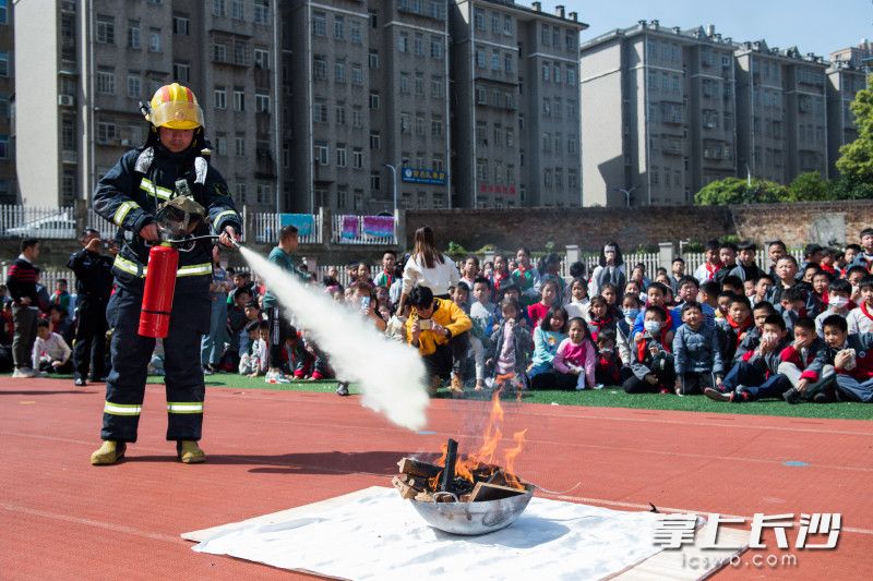 消防員現(xiàn)場演示干粉滅火器的使用方法。