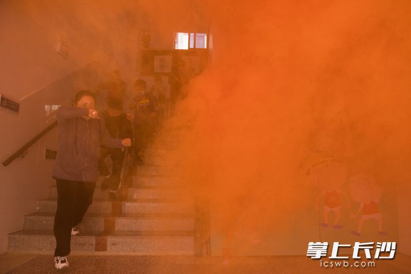 在演練現(xiàn)場，同學們用濕毛巾捂住口鼻,，有序進行疏散,。均為長沙晚報全媒體記者 黃啟晴 攝