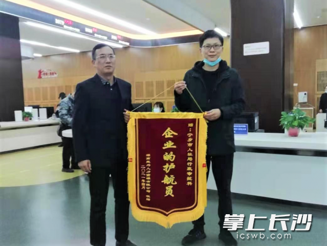 湖南楚為人力資源有限公司負責人手捧一面寫有“企業(yè)的護航員”字樣的錦旗，送到了寧鄉(xiāng)市人社局窗口以表達感激之情,。長沙晚報全媒體記者 張禹 通訊員 劉軼軍 攝影報道