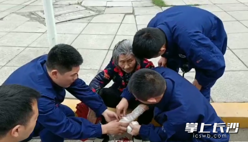 消防員為老人包扎傷口,。視頻截圖