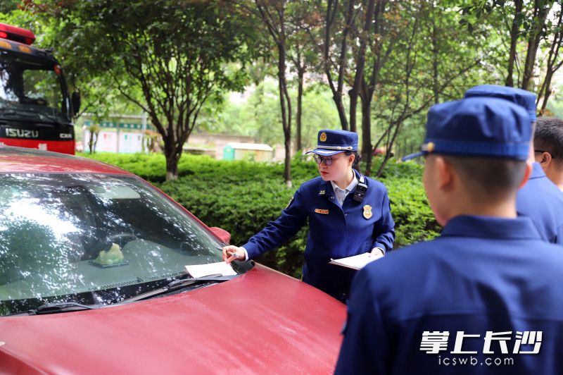消防監(jiān)督員對違停車輛進行處罰。