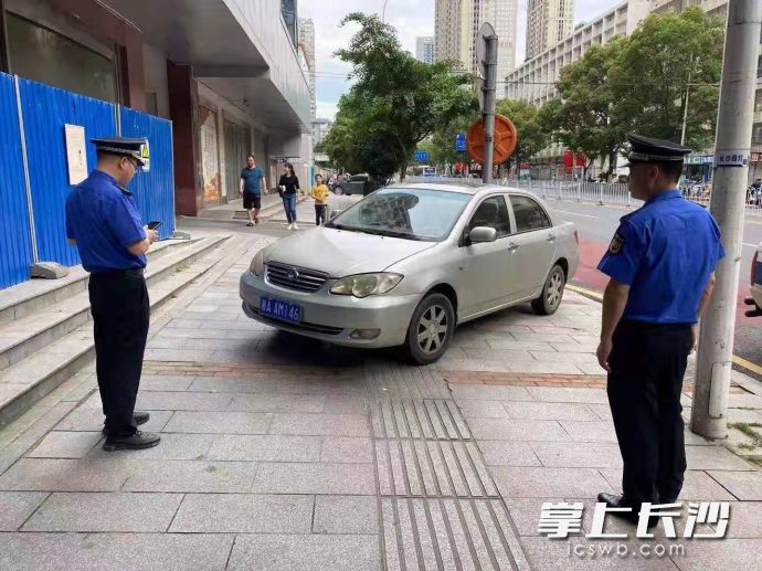 芙蓉區(qū)行政執(zhí)法人員正在對占道違停車輛進行處置,。