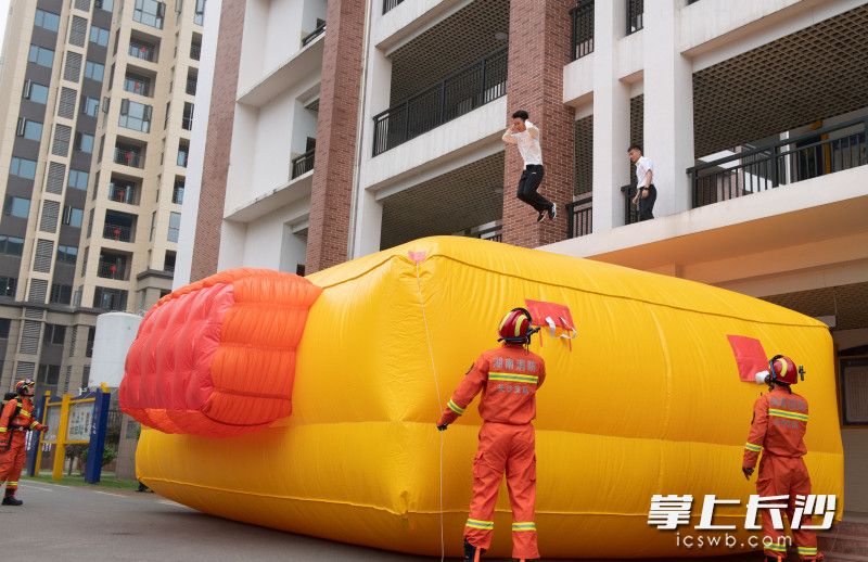消防指戰(zhàn)員第一時(shí)間打開消防救生氣墊,，指導(dǎo)“被困人員”安全跳落,。