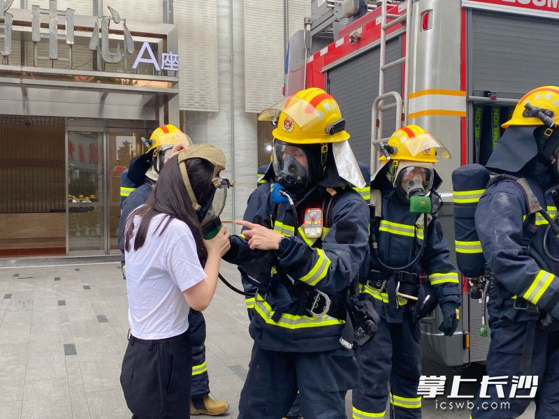 消防員為“被困人員”佩戴他救面罩并將其救出,。