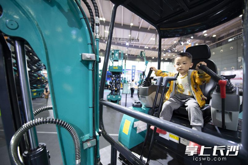 在山河智能展臺,，一位小朋友在靜態(tài)體驗(yàn)挖機(jī)的快樂,。