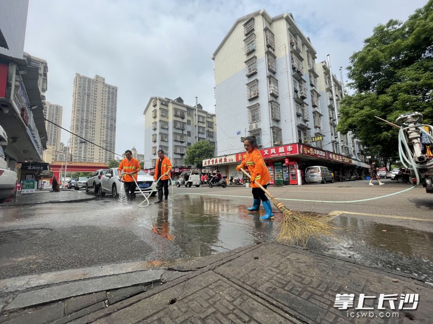 環(huán)衛(wèi)清掃保潔員將路面沉積的泥沙沖洗干凈,。  均為長(zhǎng)沙晚報(bào)全媒體記者唐朝昭攝