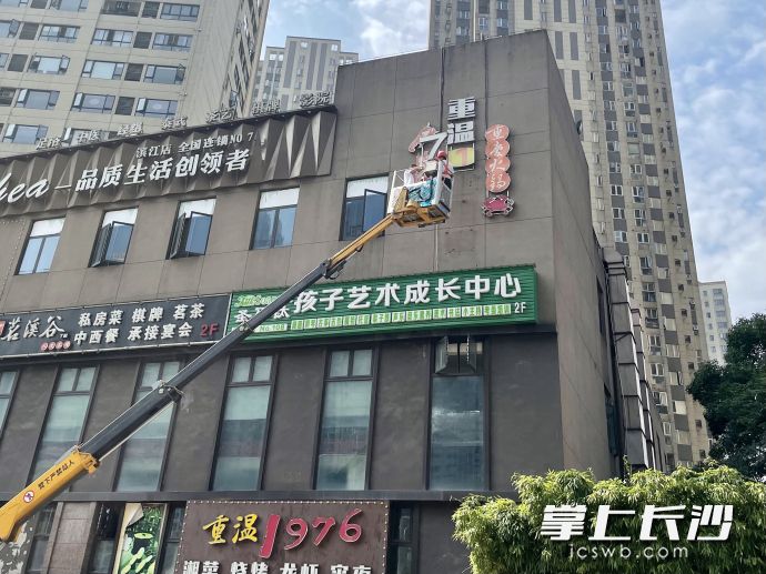 今日上午,，岳麓區(qū)城管執(zhí)法人員組織施工人員對(duì)含光路一處違規(guī)招牌實(shí)施拆除,。長(zhǎng)沙晚報(bào)全媒體記者 唐朝昭 攝