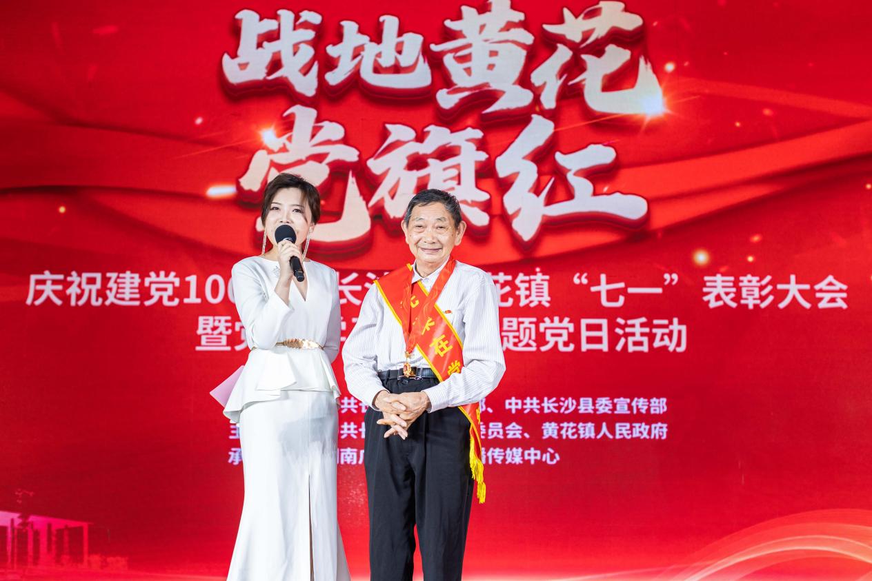 主持人在現場采訪老黨員代表王再德