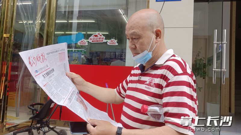 在長沙,，街頭巷尾,，市民認(rèn)真閱讀7月1日當(dāng)天的《長沙晚報(bào)》。長沙晚報(bào)實(shí)習(xí)生 曾雅文 攝
