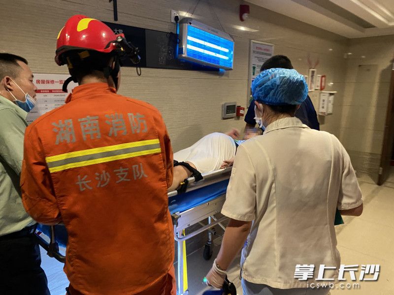 消防員成功將孕婦從30樓轉(zhuǎn)運至1樓，準備送上救護車,。
