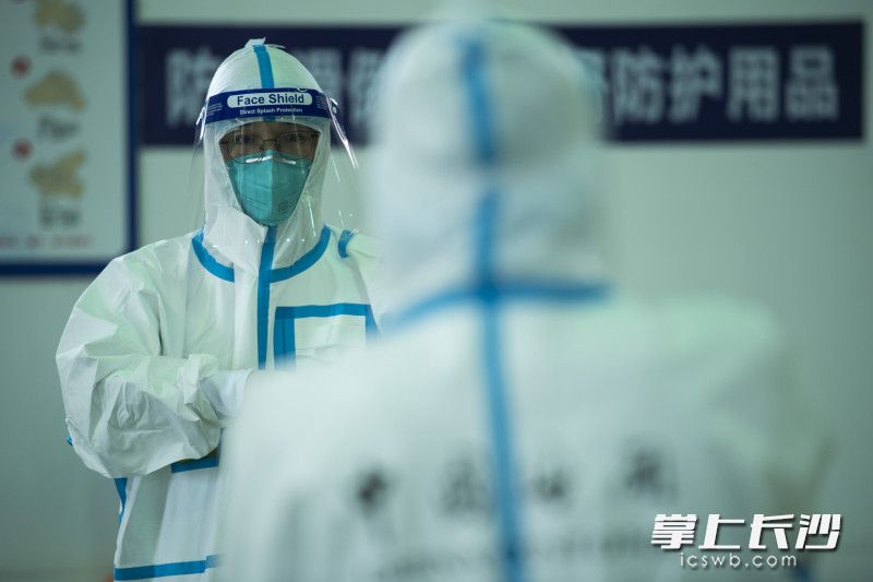 查驗前,，海關(guān)工作人員仔細(xì)地穿上防護(hù)服。