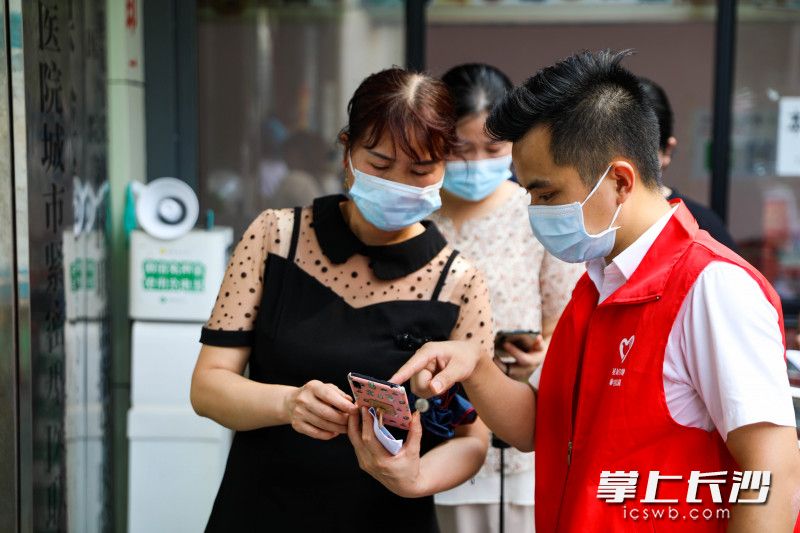 8月3日下午，在荷花園街道社區(qū)衛(wèi)生服務(wù)中心門前,，星城學(xué)雷鋒志愿者們?yōu)槭忻窠獯鹦鹿谝呙缃臃N問(wèn)題,。