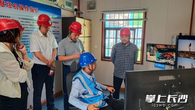 塔機(jī)司機(jī)正在進(jìn)行遠(yuǎn)程智控系統(tǒng)操作示范。通訊員 丁未供圖