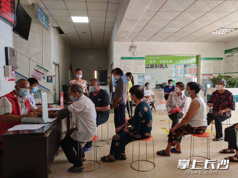 在寧鄉(xiāng)市壩塘鎮(zhèn)，衛(wèi)生院工作人員為排隊接種疫苗的老人專門準備了凳子，并提醒他們保持安全間隔距離。 長沙晚報通訊員 崔祥武 供圖