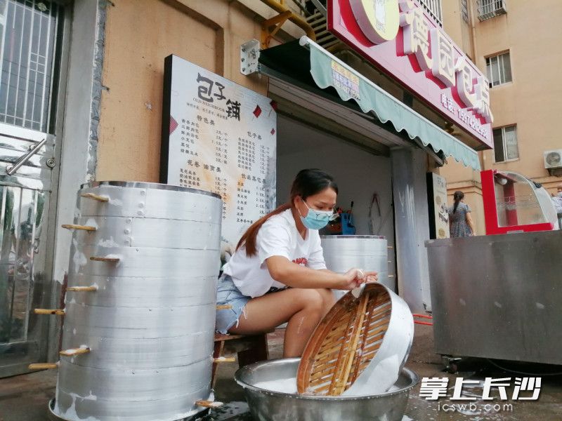 小區(qū)內(nèi)的包子店老板娘在清洗工具準備開業(yè)。