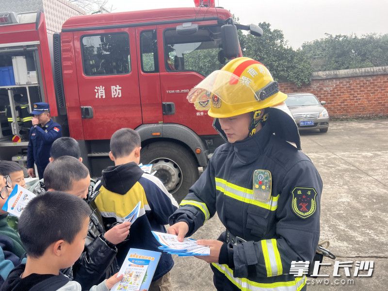“火焰藍”向同學(xué)們發(fā)放消防安全知識讀本,。