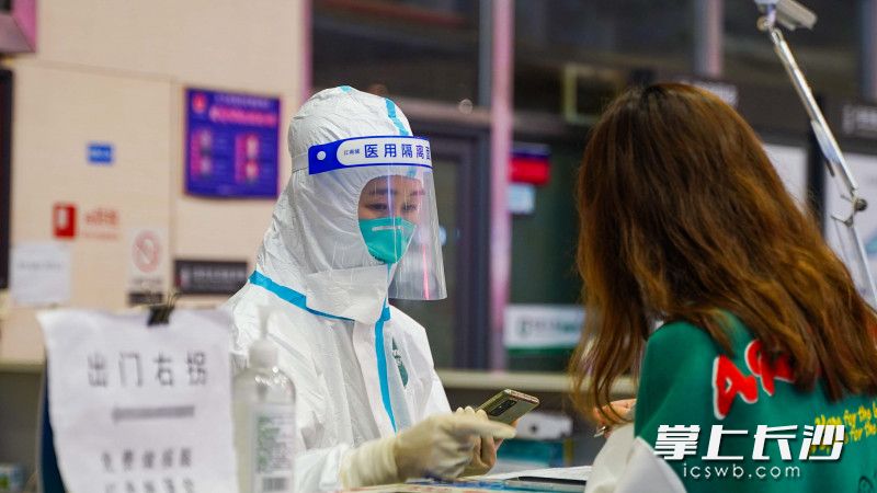 健康監(jiān)測(cè)點(diǎn)處，檢測(cè)人員正在登記旅客信息,。