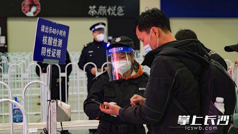 長(zhǎng)沙火車南站保安正在檢查乘客健康碼和場(chǎng)所碼,。