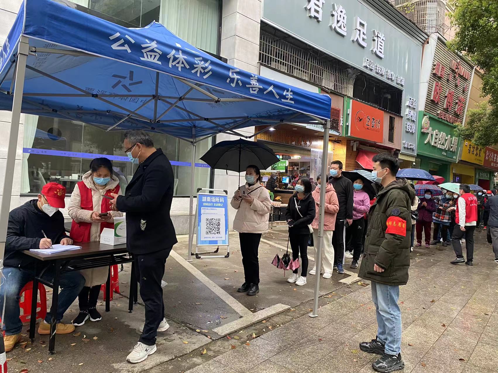 蔣戀峰（右一）正在社區(qū)核酸采樣點(diǎn)維持秩序,。受訪單位供圖
