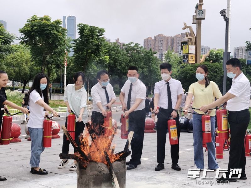 商場員工現(xiàn)場學(xué)習(xí)滅火技能,。
