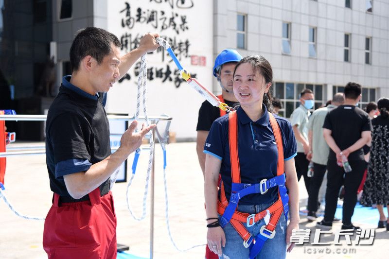 工作人員現(xiàn)場演示安全帶的使用方法。