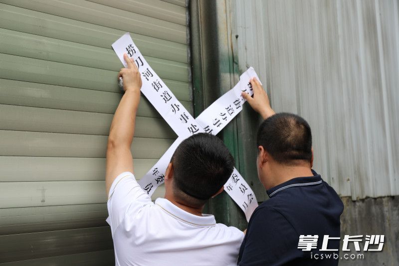 街道工作人員依法對企業(yè)實施關停。