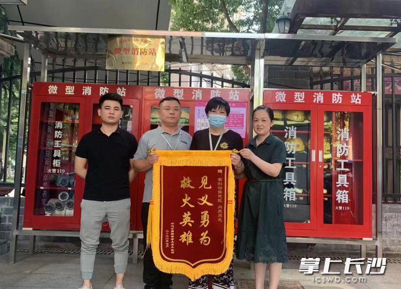 小區(qū)業(yè)委會給向慶（左二）送來錦旗。開福應(yīng)急 供圖