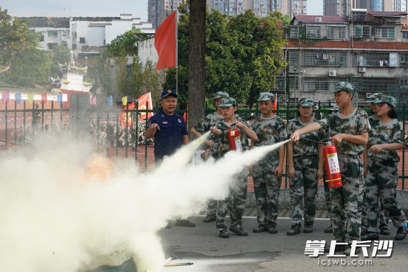 在瀏陽市第一中學(xué)，“火焰藍(lán)”教正在軍訓(xùn)的學(xué)生使用干粉滅火器,。長沙晚報通訊員 尋艷 供圖