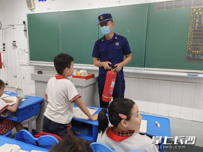 在開福區(qū)國慶小學(xué)，“火焰藍(lán)”深入課堂，為學(xué)生講滅火器的使用方法,。長沙晚報通訊員 劉荃菁 供圖