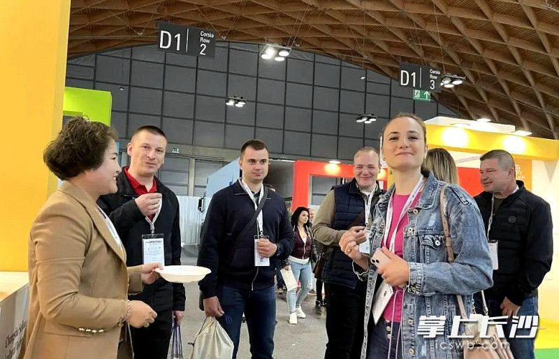 長(zhǎng)沙穗寶農(nóng)業(yè)科技有限公司的工作人員（左一）在展會(huì)向客商推存品嘗無(wú)花果干,。受訪者 供圖