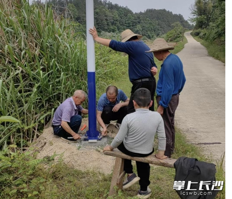 灰湯鎮(zhèn)雙建村西沖組村民代表帶領(lǐng)群眾一起安裝路燈。