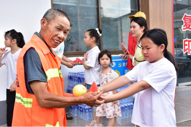 小小志愿者為環(huán)衛(wèi)工送上西瓜,。