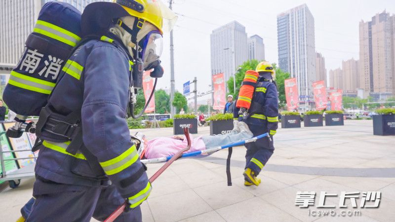 消防人員將排查發(fā)現(xiàn)的“昏迷人員”解救出現(xiàn)場。