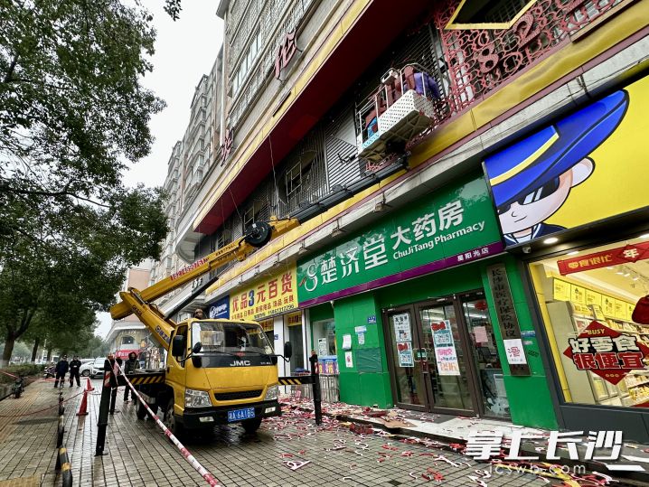 在井灣路上，雨花區(qū)城管部門正組織專業(yè)施工人員對沿線存在消防安全隱患的違規(guī)招牌實施拆除,。長沙晚報全媒體記者 唐朝昭 攝