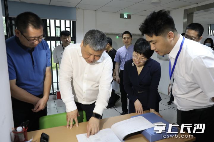 在醫(yī)院消控室，陳剛仔細(xì)察看消防值班臺賬,。  長沙晚報通訊員 黃順澤 攝