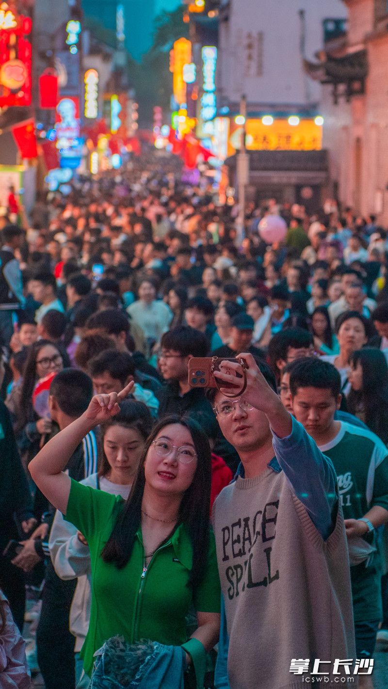 兩位游客在人頭攢動的太平老街自拍。