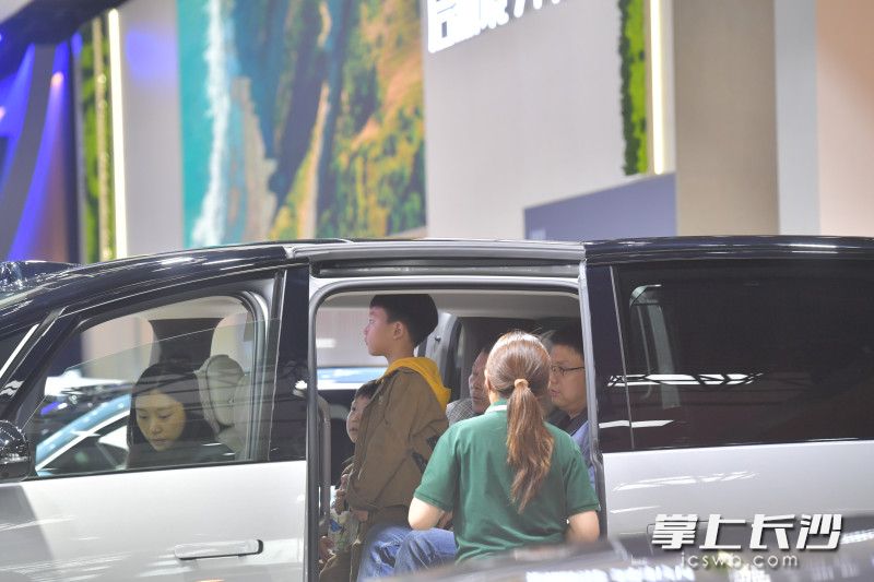 理想汽車展臺(tái),，顧客正坐在車上體驗(yàn),。