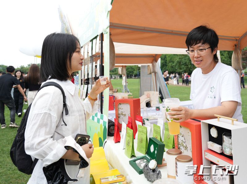 一位市民正在體驗梔子花茶飲新品,。
