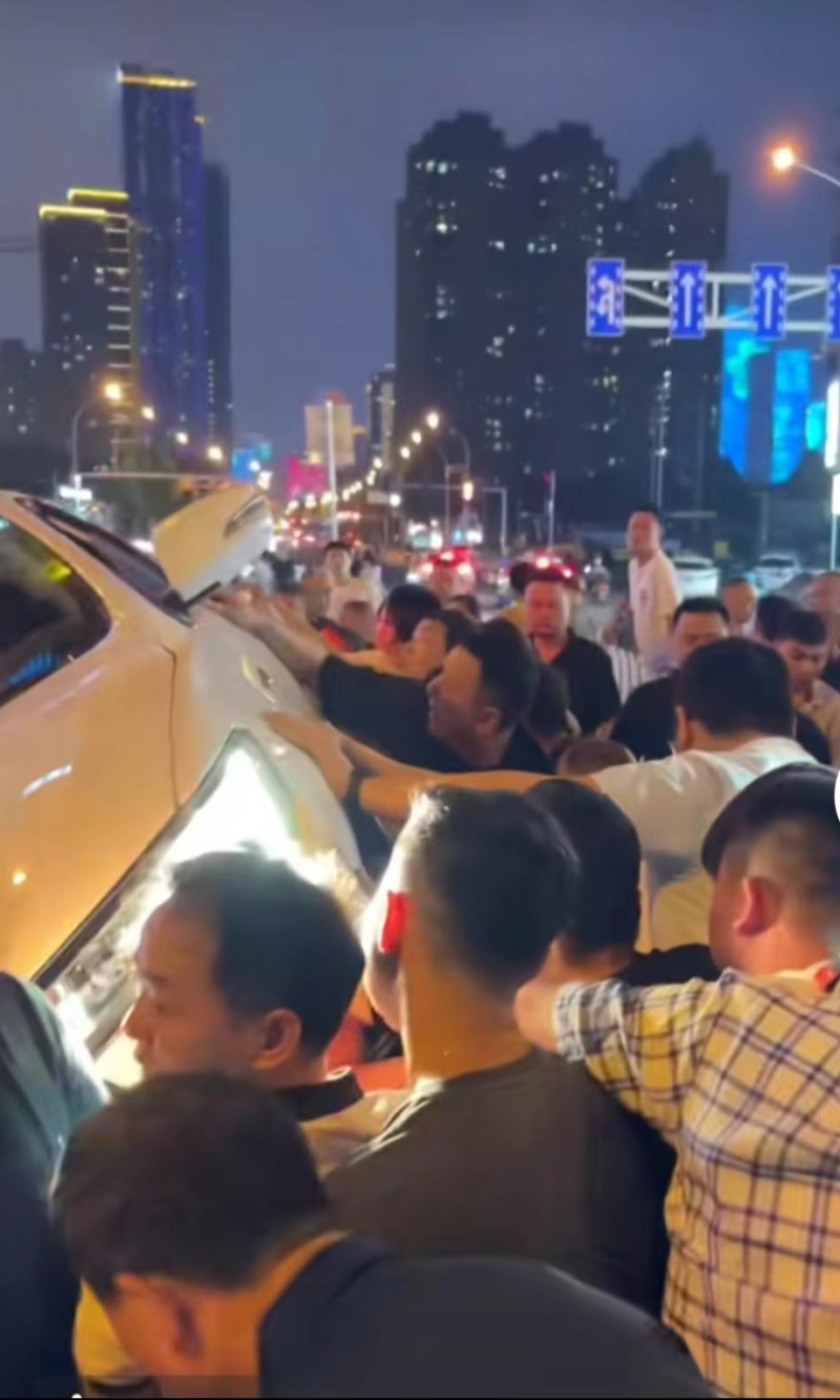 事故現(xiàn)場(chǎng)聚集了二十多人合力抬車,。