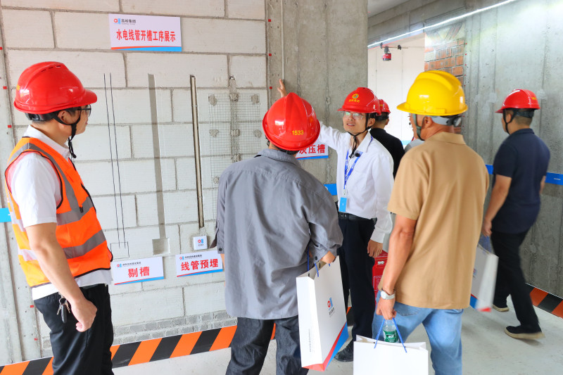 與會人員正在高沖路以南農(nóng)民安置房工程觀摩,。